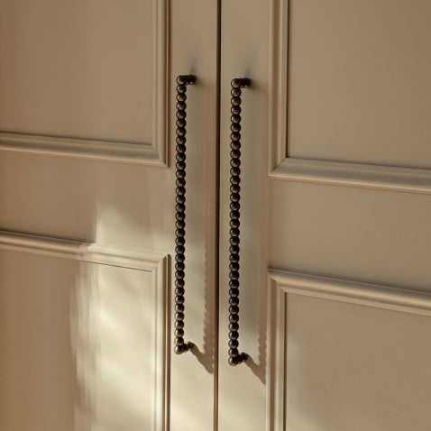Cream closet doors with antique brass bobbin pulls