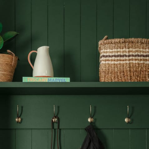 Forest green boot room hallway with traditional brass hooks