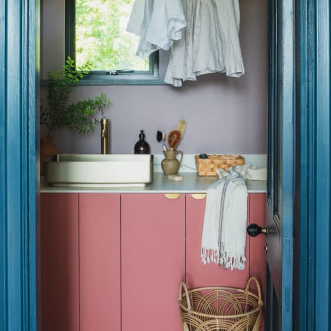 Pink and blue laundry room with brass edge pulls